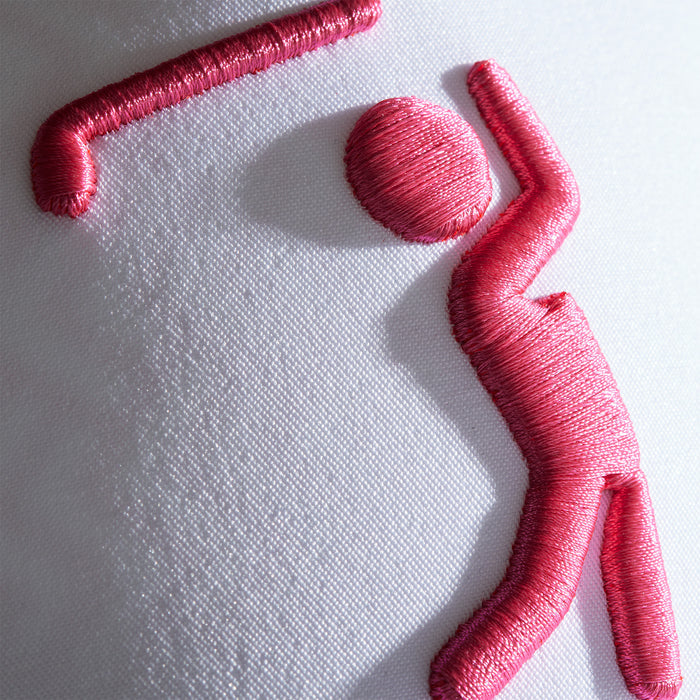 Close-up of pink embroidery on the Bogeyman White/Pink Performance Golf Hat (Snapback), showing a stylized figure stretching on white, sweat stain resistant material with neat, glossy stitching.