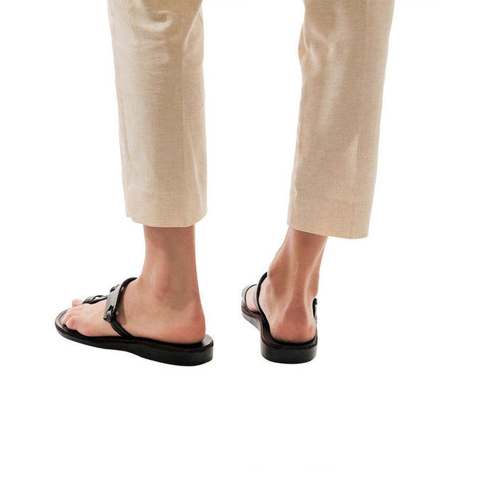 Model wearing David black, handmade leather slide sandals with toe loop