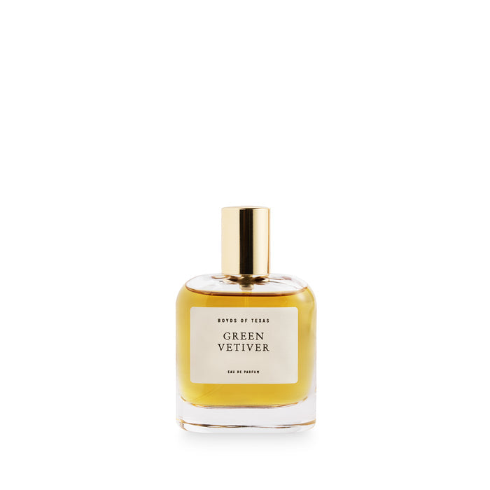 A glass bottle of perfume/cologne by Boyd's of Texas filled with a golden liquid fragrance topped with a polished brass cap
