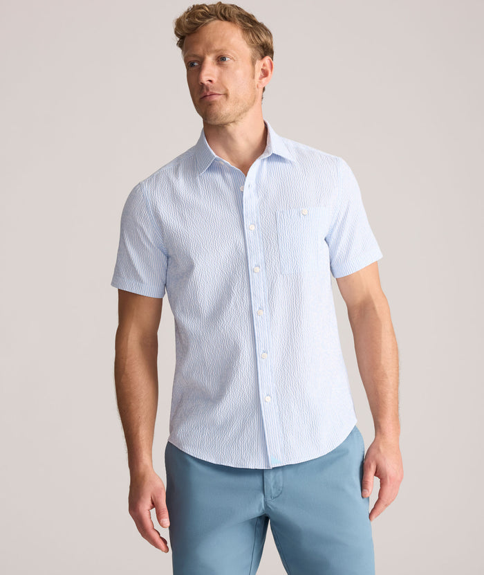 Model is wearing UNTUCKit Forbes performance seersucker short sleeve shirt in cerulean.
