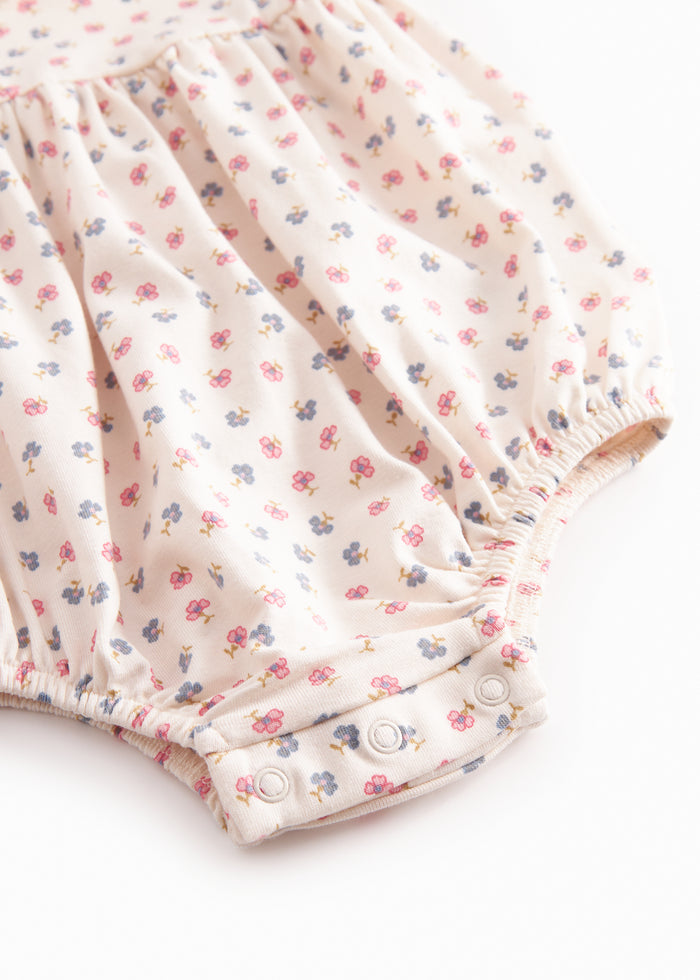 Langærmet baby bodystocking with ruffled collar or floral print