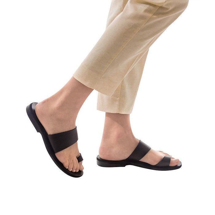 Model wearing Abra black, handmade leather slide sandals with toe loop