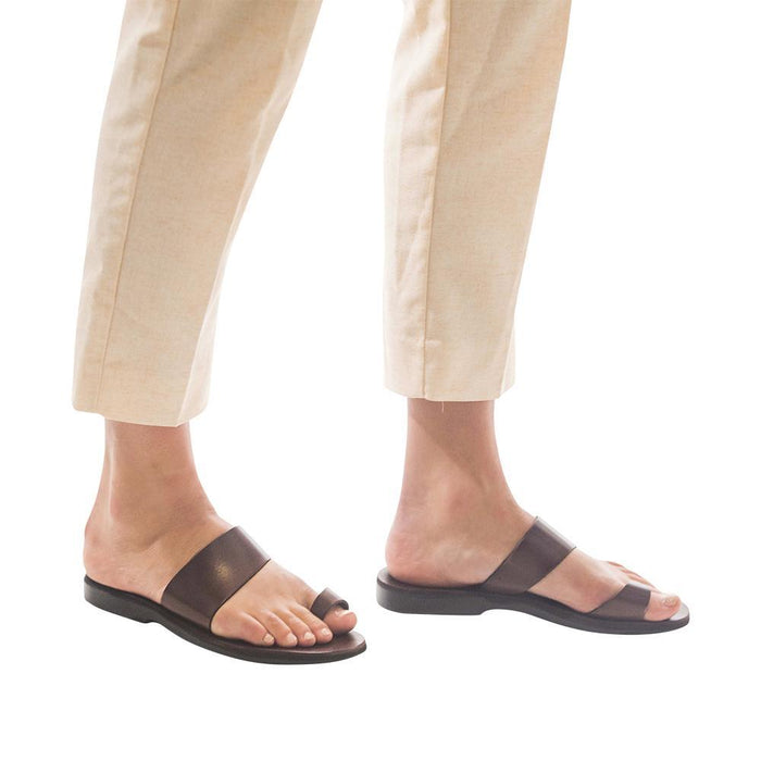 Model wearing Abra brown, handmade leather slide sandals with toe loop