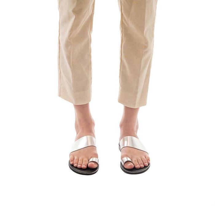 Model wearing Abra silver, handmade leather slide sandals with toe loop