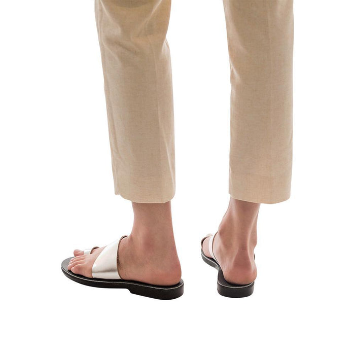 Model wearing Abra silver, handmade leather slide sandals with toe loop