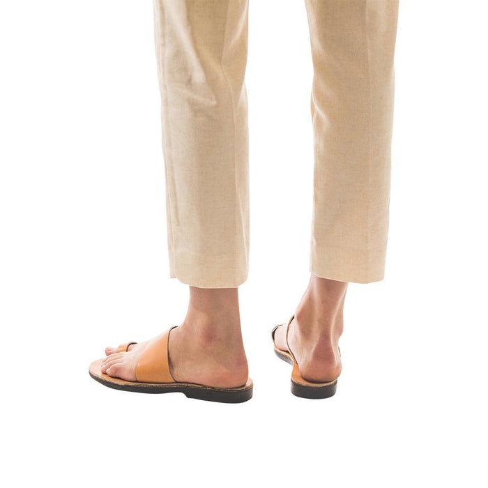 Model wearing Abra tan, handmade leather slide sandals with toe loop