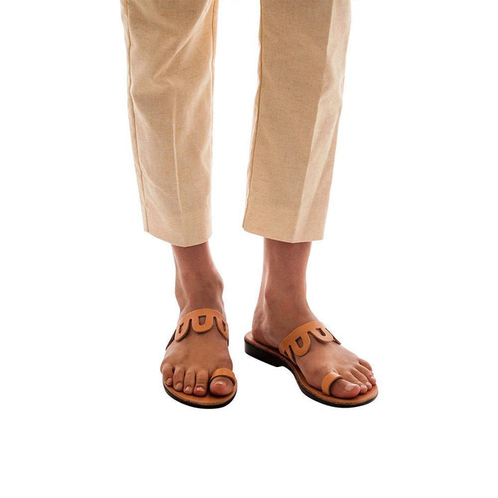 Model wearing Aja tan, handmade leather slide sandals with toe loop