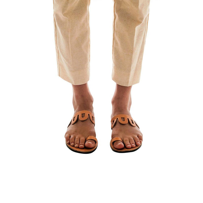 Model wearing Aja tan, handmade leather slide sandals with toe loop