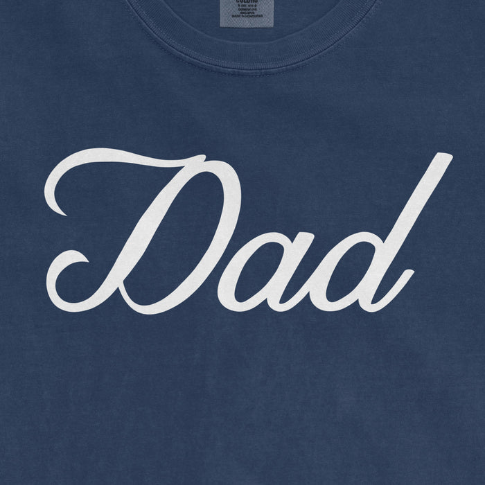 Blue Comfort Colors T-shirt with white "Dad" text in cursive font, designed for Bronx baseball dads.
