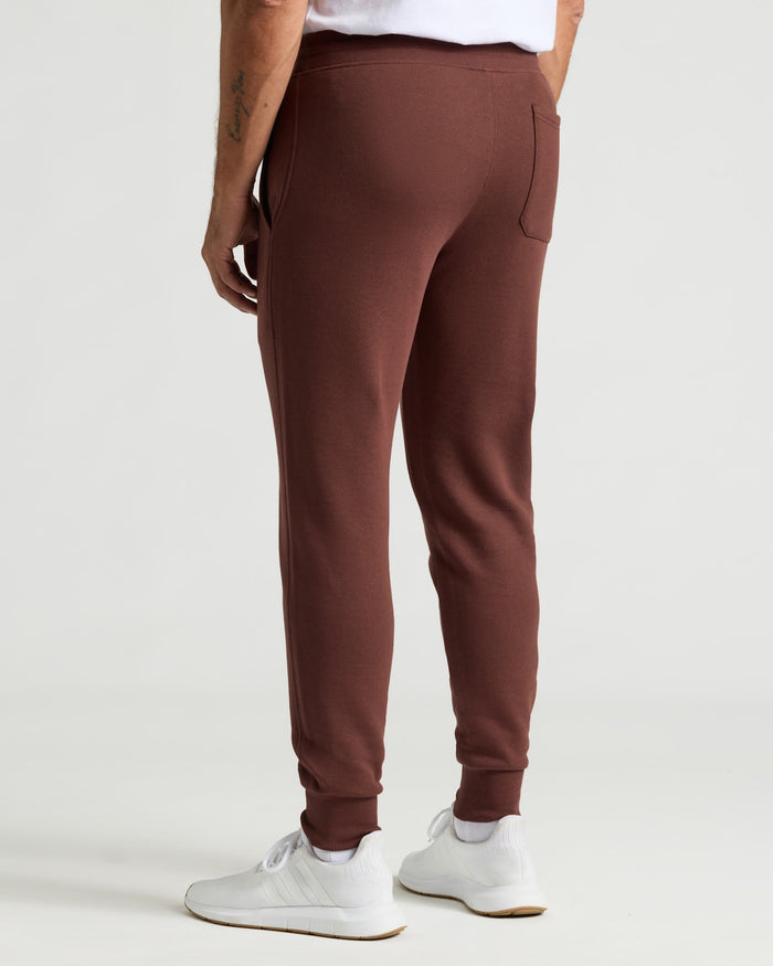 Carob Fleece French Terry Jogger with white sneakers, rear view.