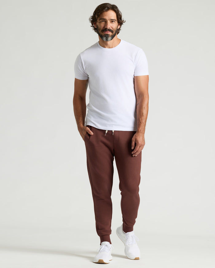 Man wearing Carob Fleece French Terry Joggers with white T-shirt and sneakers.