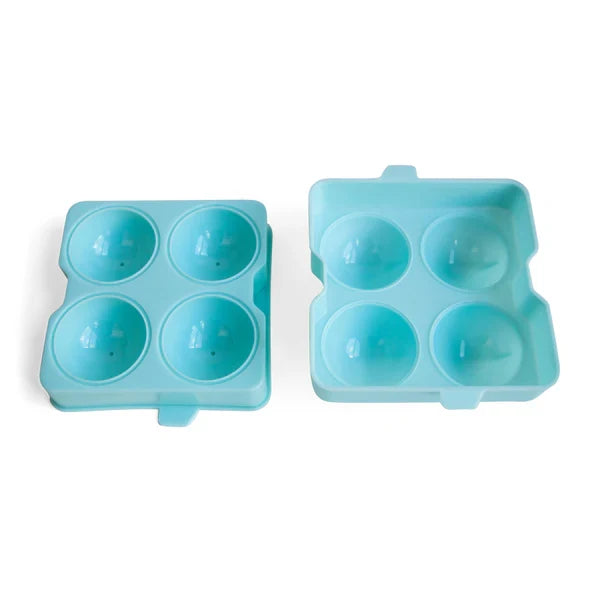 A blue ice sphere tray filled with four spherical ice molds for cocktails on white background.