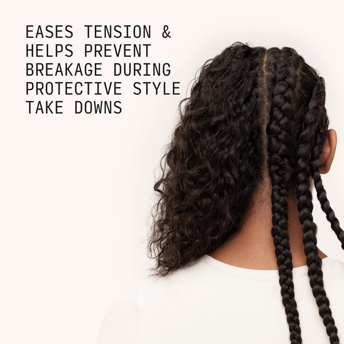 Person with protective style featuring braids and loose curls on a white background. Eases tension & helps prevent breakage during protective style take downs.
