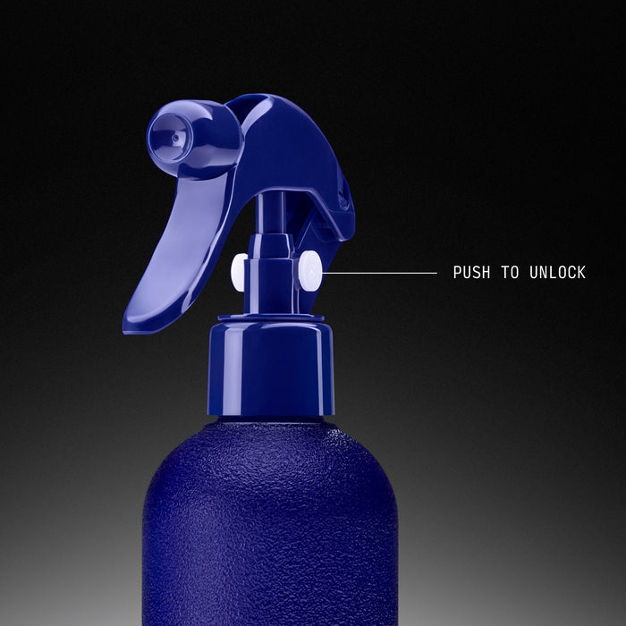 Navy blue spray bottle with trigger handle and push-to-unlock safety mechanism on textured container.
