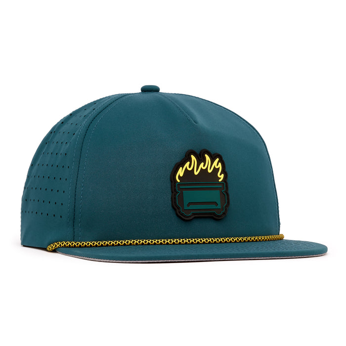 The Dumpster Fire - Unstructured Flat Bill Hat - Snapback is a teal hat made from performance fabric with perforated sides, a flat brim, a gold braided rope, and a front patch of a stylized grill with yellow flames.
