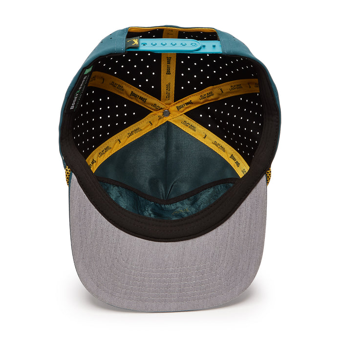 The Dumpster Fire Unstructured Flat Bill Snapback Hat is shown from above, revealing its yellow criss-cross sweatbands with black and white text, blue adjustable strap, black lining with white dots, and grey underside of the brim.