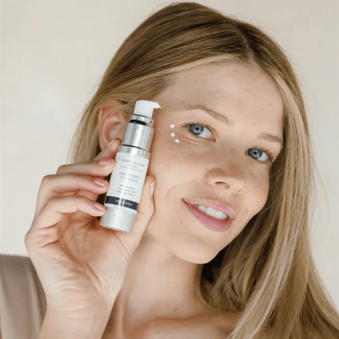 Woman applying Enlightened Eye Cream | DermaplanePro to under-eye area, demonstrating gentle skincare routine for refreshed and hydrated skin.