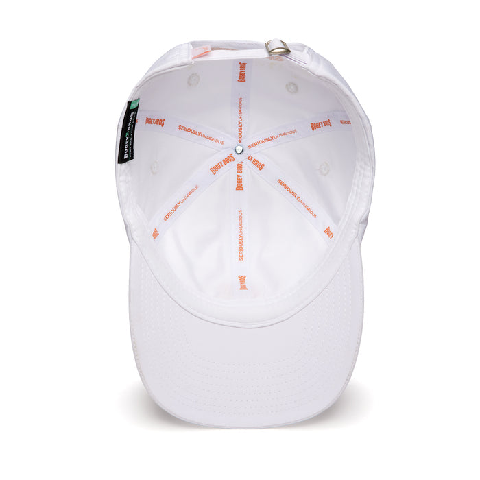 The In Bloom - Dad Hat is a white baseball cap shown from above, revealing its interior sweatband and orange SERIOUSLYHANDSOME and PEANUTS text along the seams, plus an adjustable strap with metal buckle and a black tag with green and white detail.