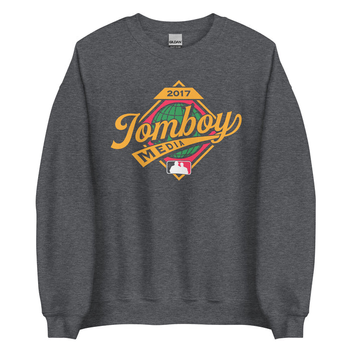 Gray crewneck sweatshirt featuring a colorful "Tomboy Media" logo with a globe, year 2017, and MLB-style silhouette design.