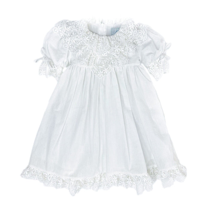 Katherine white linen girls dress with embroidered lace detail, large back tie bow, below the knee silhouette, and lightweight fabric.