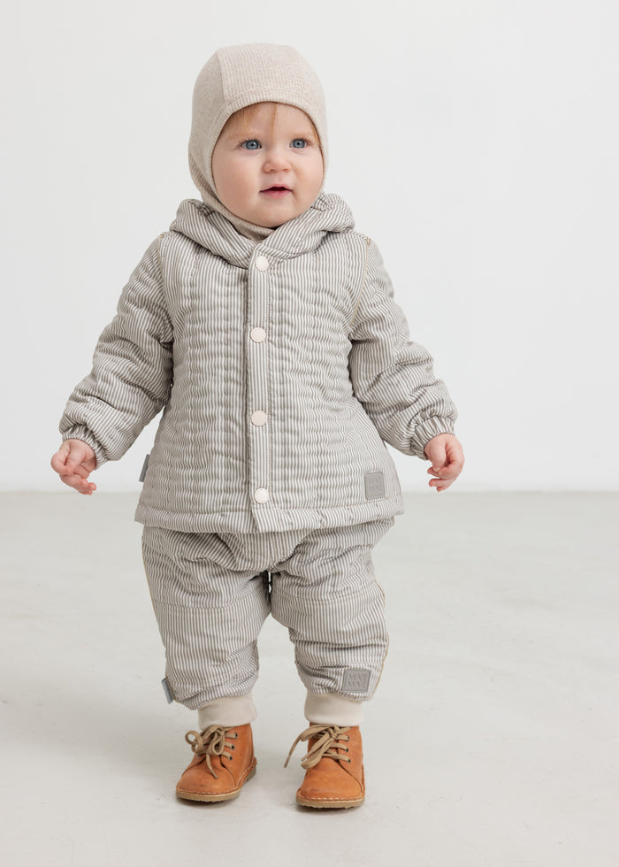 Baby wearing beige thermal pants, matching jacket and hat