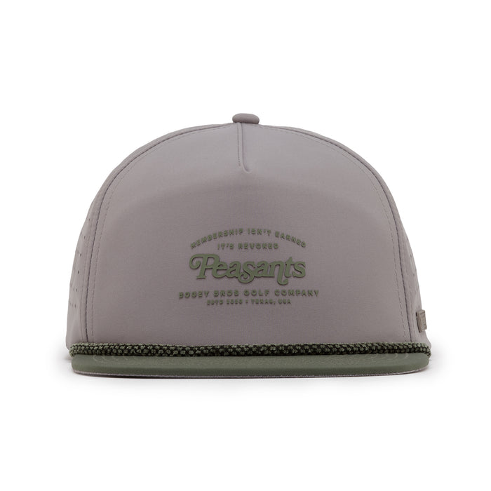 The Revoked Unstructured Flat Bill Hat is a light gray snapback with green embossed "Peasants" text, smaller lettering above and below, a green-trimmed flat brim, and a subtle logo tag on the lower left side.