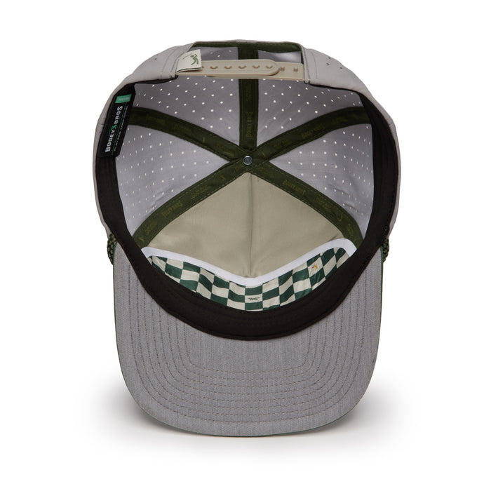 The image shows the inside of the Revoked - Unstructured Flat Bill Hat - Snapback, featuring grey fabric, green and white checkered performance lining, a black sweatband, green stitched seams, perforated crown lining, and a white adjustable snapback strap.