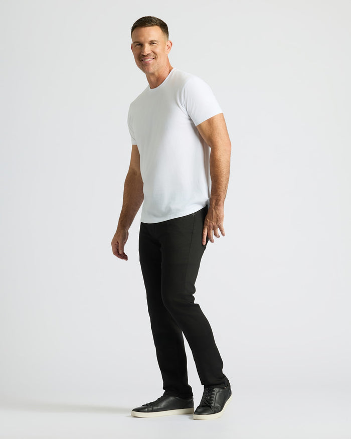 Man wearing a white t-shirt and black pants on a white background