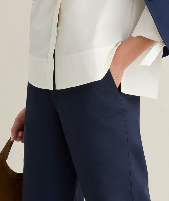 Model is wearing UNTUCKit Ava trousers in navy.