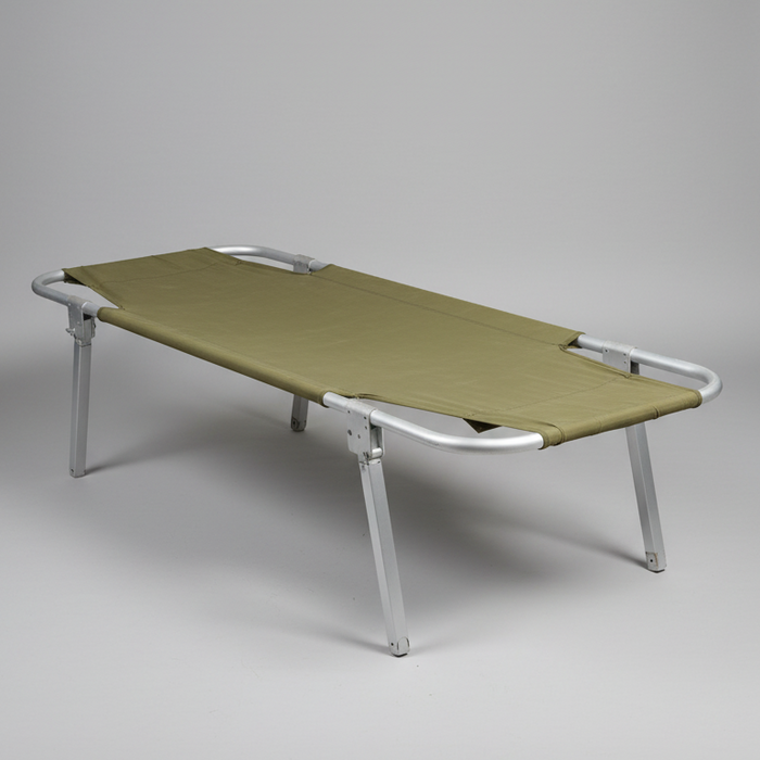 Green camping cot with metal frame on a gray background